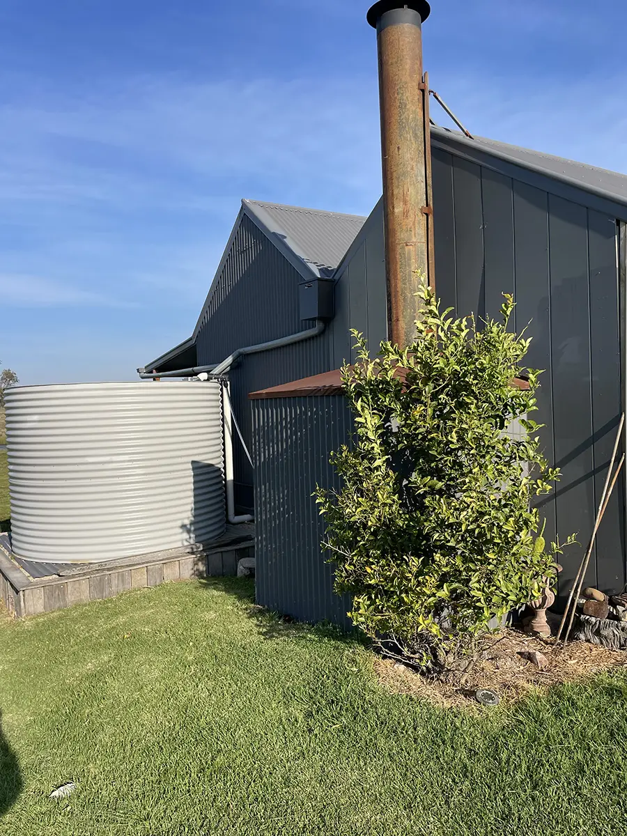 Farm building exterior with water tank and chimney